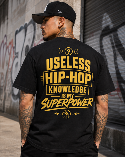 Superpower Tee worn from behind — Useless Hip-Hop Knowledge Is My Superpower printed across the back