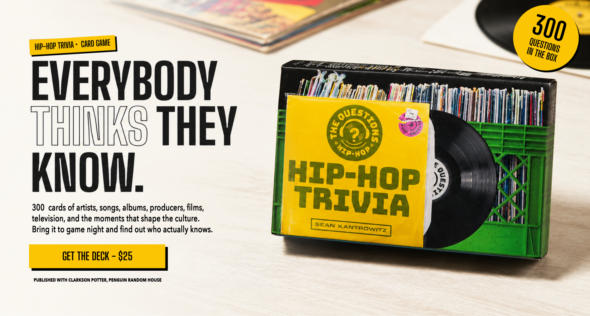 Hip Hop Trivia card deck box on a light wood tabletop next to promotional text. The box is yellow and black with a green vinyl record graphic, and the background shows a blurred record store setting with records and a yellow '300+' badge.